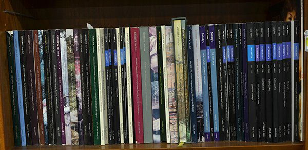 Auction Catalogs: Collection of auction catalogs on three shelves, mostly art and photography, including Christie's Swann and Sothebys