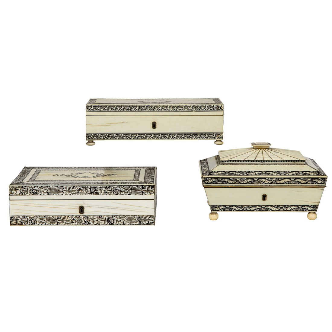 Three Anglo-Indian engraved bone table boxes: Three Anglo-Indian engraved bone table boxes, Vizagapatam, 19th century, comprising one of casket form with removable compartmentalized tray and two of rectangular outline centering a wreath, greatest
