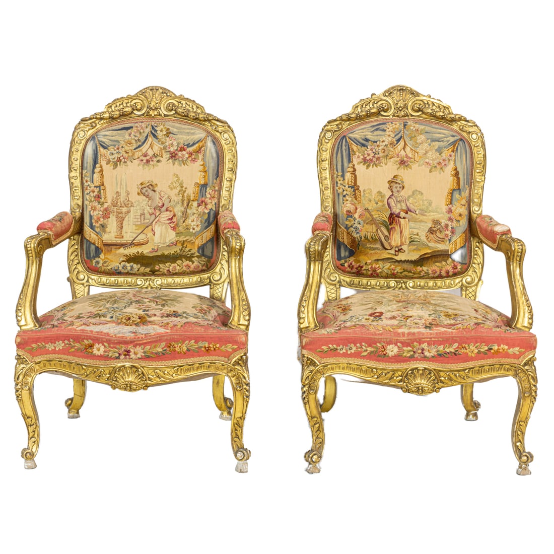 A pair of French Louis XV style giltwood carved fauteuils circa 1860: A pair of French Louis XV style giltwood carved fauteuils circa 1860, each having a garland swag decorated crest surmounting the upholstered seat and back, depicting child musicians, the serpentine se