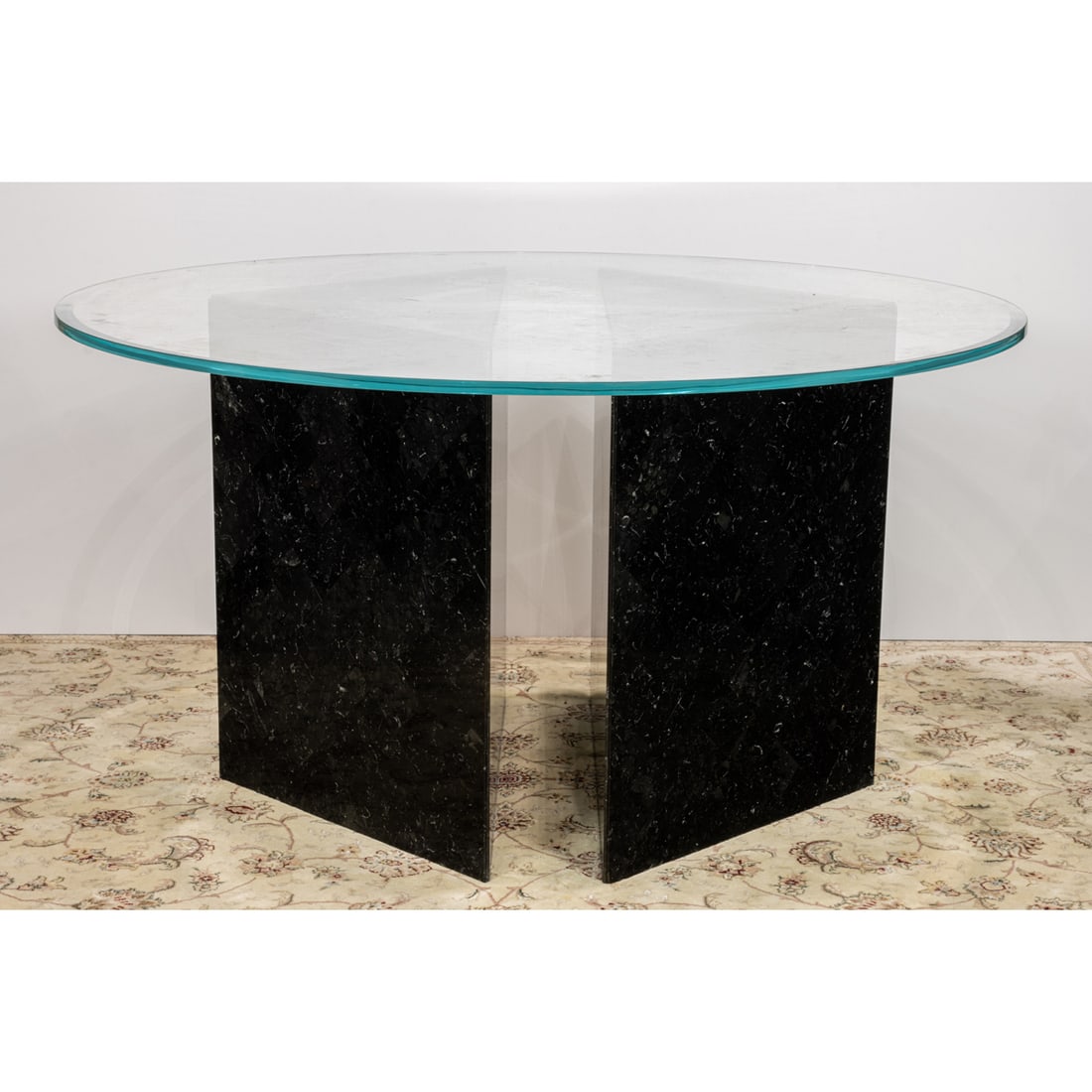 A Modern Italian circular beveled glass top table rising on two black veneered triangular plinth: A Modern Italian circular beveled glass top table rising on two black veneered triangular plinth bases, 30"h x 53.75"d