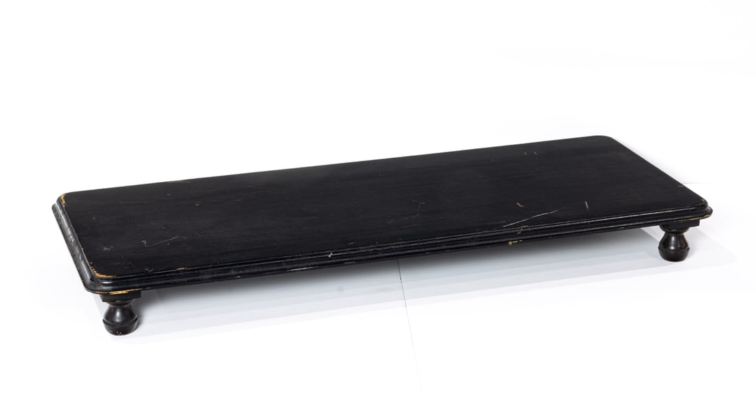 A large ebonized wood stand: A large ebonized wood stand, raised on four turned feet, 4"h x 35"w x 14"d