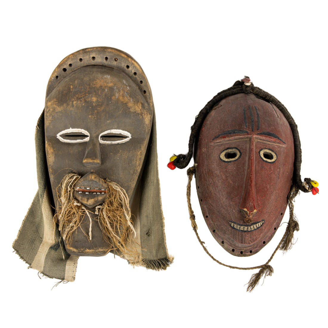 Two African masks: Two African masks, comprising a Yoruba mask with deliberate thin nose and Liberian Dan Complex mask with blue stripe fabric