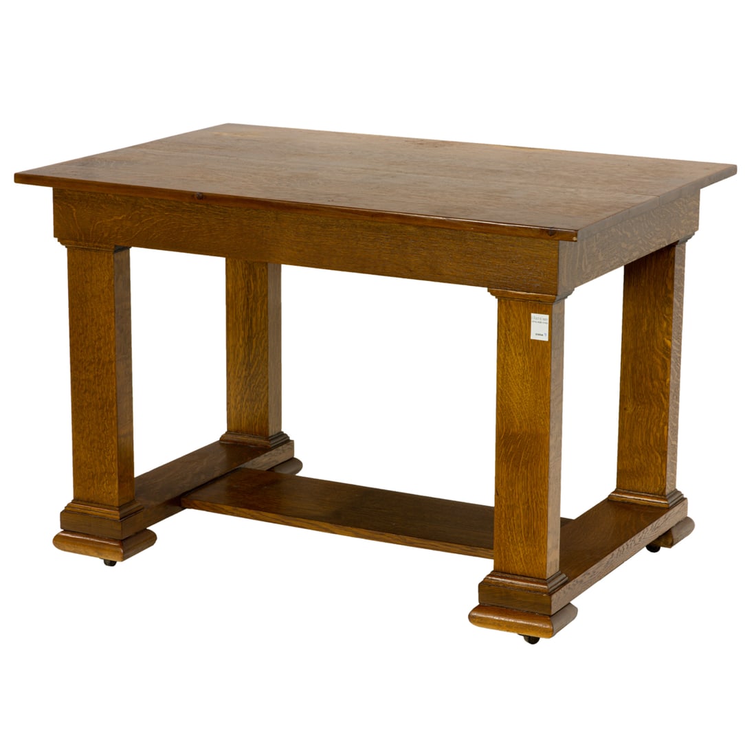 An Arts and Crafts oak quartersawn desk: An Arts and Crafts oak quartersawn desk, the six board top over a long drawer frieze rising on stylized columnar stiles, joined by a h-constructed boards, the whole atop caster legs, 29.5"h x 44"w x 3