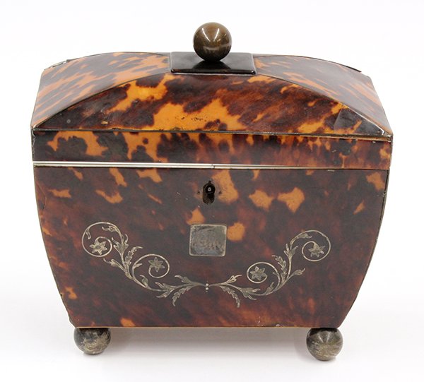 Tortoise shell tea caddy: Tortoise shell tea caddy. 19th century, of casket form, having a spherical knop opening to the fitted interior, the tapering case accented with a floral inlaid reserve and rising on ball feet, 7"h x 7