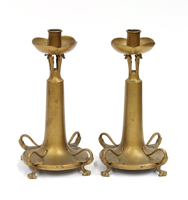Pair of American Art Nouveau patinated metal cand: Pair of American Art Nouveau patinated metal candle holders, executed by Pairpoint Mfg. Co., the organic examples with a floral receiver above the leaf form supports and rising on a trumpet form base 