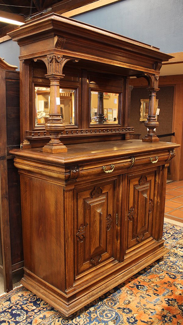 Henri II style walnut buffet circa 1885, the hood: Henri II style walnut buffet circa 1885, the hooded superstructure having two mirrored and bevelled panels fronted by baluster turned supports, above the lower case having carved and panelled door fro