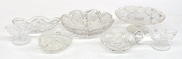 Cut glass table accessories: (lot of 7) Cut glass table accessories including a pedestal pastry stand, relish tray, bowl, spoon rest, nappy, and a pair of pedestal salts, all having diamond, cross-hatch, and hobstar patterns