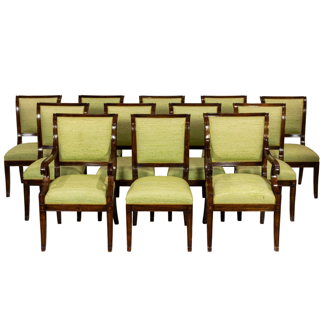 A set of twelve Regency style dining chairs: A set of twelve Regency style dining chairs, each padded trapezoidal back over two down scrolling arms, the seat and back in green silk upholstery, rising on sabre legs, each chair base with gilt stam