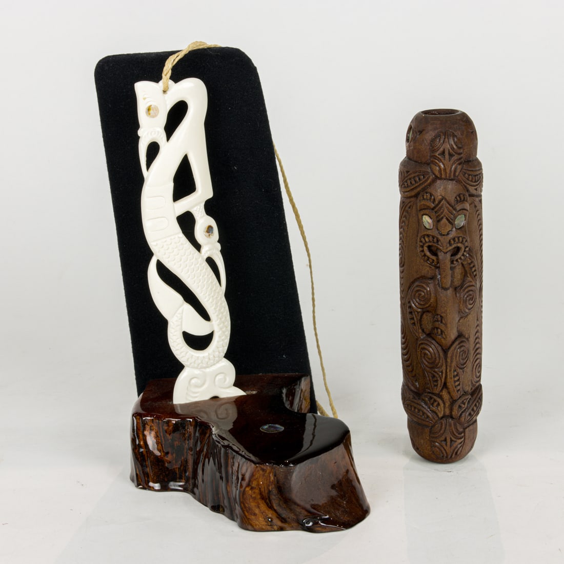 Two Maori shell inlaid carved items, the first bone Manaia necklace with custom stand, 7: Two Maori shell inlaid carved items, the first bone Manaia necklace with custom stand, 7.5"h (pendant); the second a carved flute, 7.5"l