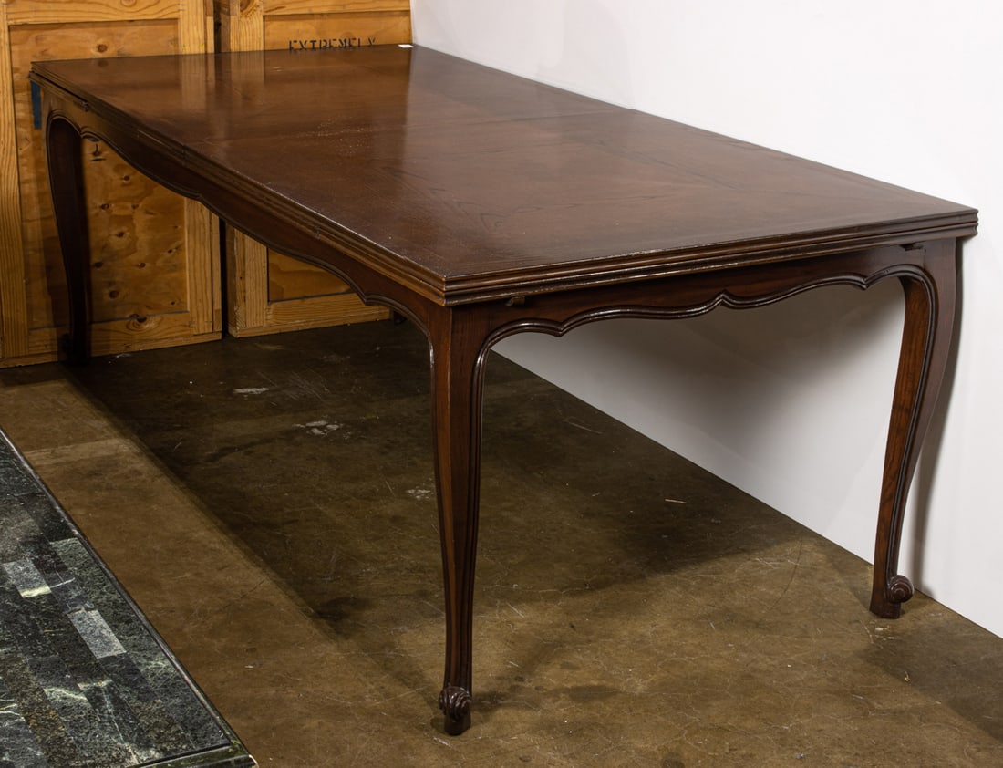 A dining table with integrated sliding cantilevered leaves: A dining table with integrated sliding cantilevered leaves to each end, over a scalloped apron, rising on stylized cabriole legs ending in outswept feet, closed 31"h x 89"w x 42"d