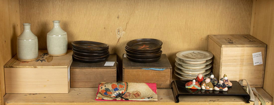 A grouping of Japanese decorative objects: A grouping of Japanese decorative objects. Including two sake bottles, five saucer dishes and ten wooden dishes, 5.25" wide. Provenance: Property of the Mitsui (Koishikawa) family, a prominent Japanes