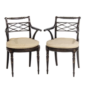 A pair of Regency ebonized and caned arm chairs