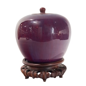 A Chinese flambe glazed covered jar with stand