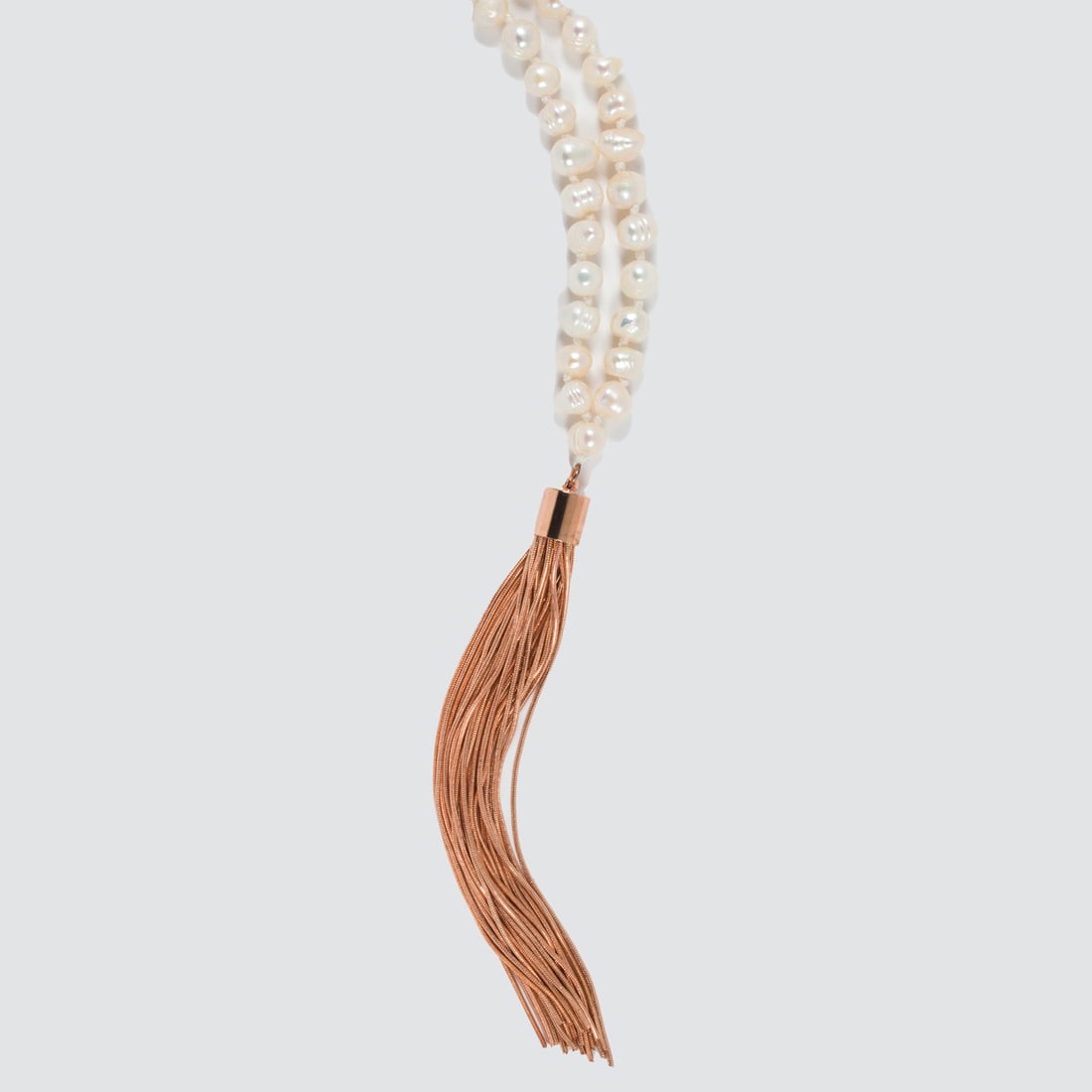 A pearl and gilt metal necklace: A pearl and gilt metal necklace designed as a line of cultured pearls suspending a gilt metal tassel; 107.12 grams; length: 38 in
