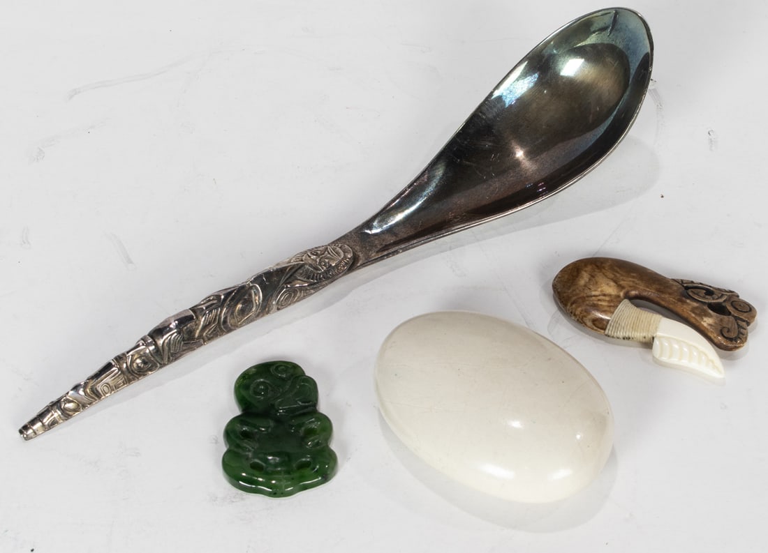 A group of Maori and Pacific Northwest decorations: A group of Maori and Pacific Northwest decorations, comprising carved bone hook; Hei-Teiki green stone pendant; paua shell inlaid carved stone and a Pacific Northwest Boma pewter spoon, 8.5"l
