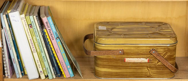 A group of reference books and a faux bois tin picnic basket or sewing basket