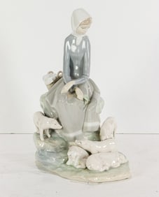 A Lladro porcelain figure of a young woman with piglets