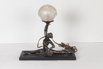 An Art Deco style patinated metal and glass figural boudoir lamp