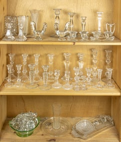 A group of mainly molded glass candlesticks and other table articles