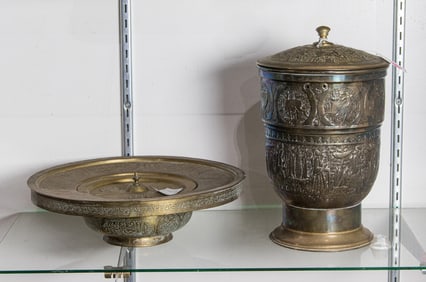 A Persian engraved brass draining basin and a covered jar