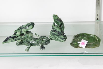 Four green stone carvings of lizards