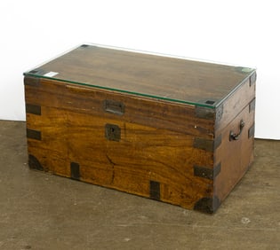 A brass bound mahogany trunk mounted with glass top as coffee table