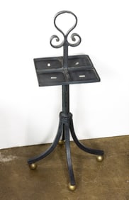 A Spanish Revival style wrought iron smoking stand raised on ball feet