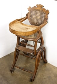 A Victorian walnut adjustable high chair with caned seat