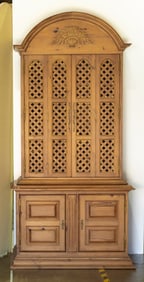 A French Provincial style pine cabinet with folding lattice doors on two-door base