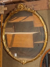 A Neoclassical style gilt round mirror with scroll crest