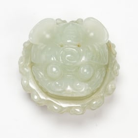 A Chinese celadon jade lion button