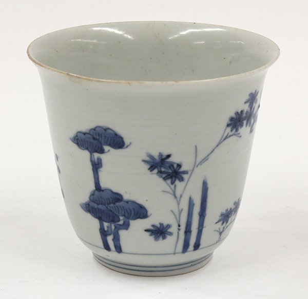Japanese Blue-and-White Porcelain Cup, Chenghua M: Japanese underglaze blue porcelain cup, of inverted bell form embellished with bamboo, prunus, and pine, the recessed base with an apocryphal Ming Chenghua mark, together with a wood stand (rim of cup