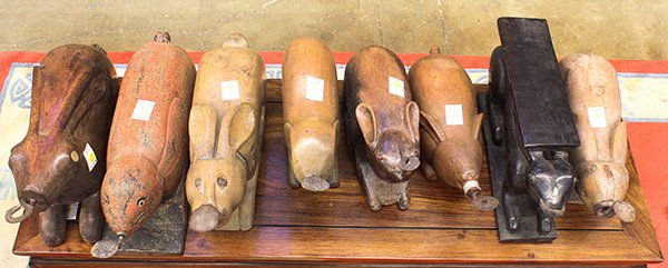 Six Thai Wood Rabbit Form Coconut Graters: (lot of 8) Thai wooden coconut graters, each shaped as a recumbent rabbit, one accented with red pigments and one with a rectangular seat on the back of the rabbit, largest: 24""l