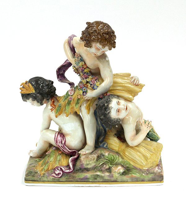 Capodimonte figural group: Capodimonte figural group. The three putti depicted in Fall harvest, each with a bountiful harvest accented with garland swags and rising on a naturalistic base, marked with underglaze crown N, 11.5""