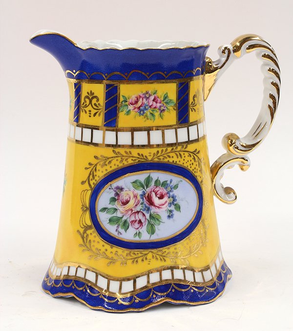 Capodimonte style pitcher: Capodimonte style polychrome decorated pitcher, the yellow ground with floral reserves, and accented by cobalt and gilt enameling, marked with a crown over N, 9""h