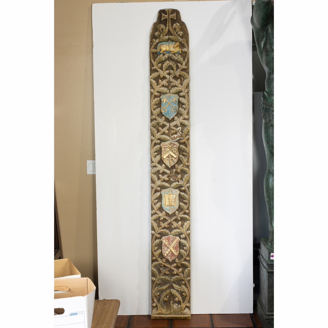 A Continental polychrome and gilt carved wood ecclesiastical panel representing the Apostle John (1 of 3)