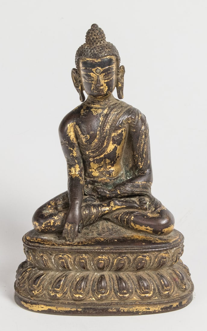 A Chinese gilt bronze Buddha figure: A Chinese gilt bronze Buddha figure. Seated in vajrasana on a lotus base, the right hand in bhumisparshamudra, the left in dhyanamudra, 5.375" high.