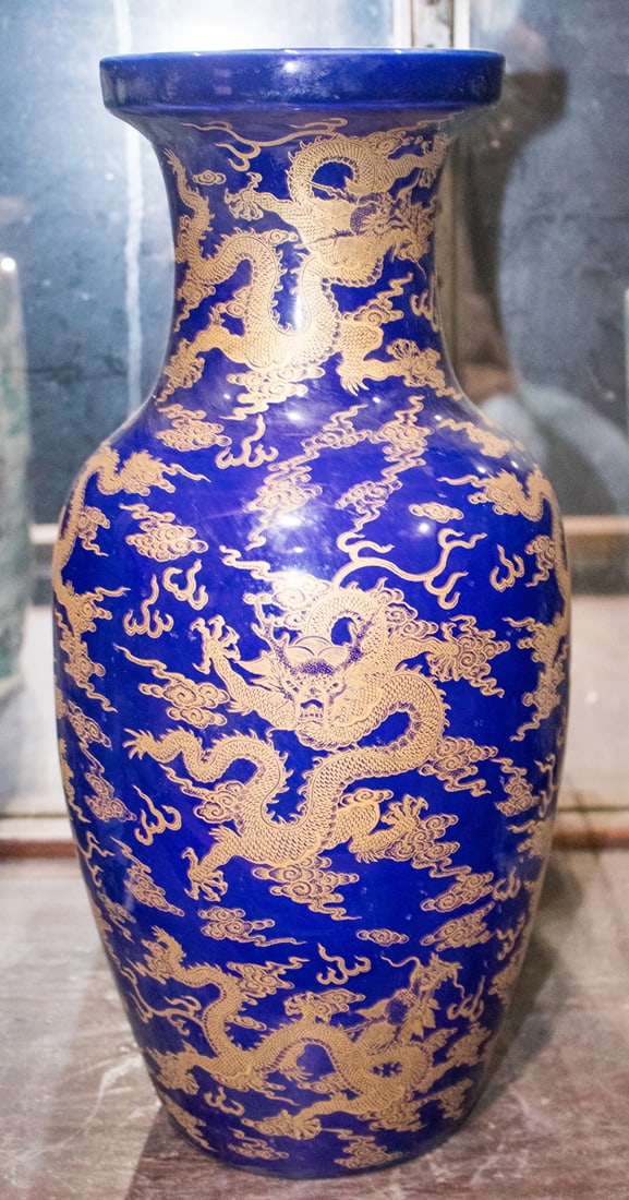 A Chinese gilt-decorated cobalt blue 'dragon' vase: A Chinese gilt-decorated cobalt blue 'dragon' vase. Featuring five-claw dragons chasing flaming pearl, Kangxi six-character mark, 17.75" high.
