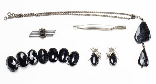 A group of silver and onyx jewelry
