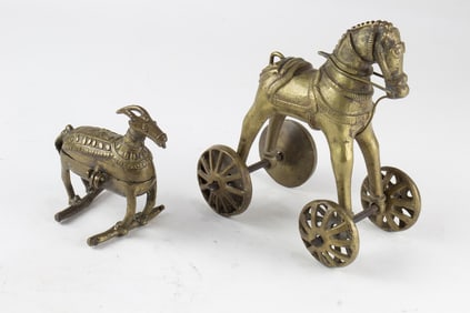 Two Indian brass figures of animals, the larger, a figural toy of horse on wheels