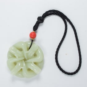 A Chinese celadon jade intertwined dragon pendant