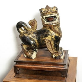 A Chinese parcel gilt carved wood foo lion with stand