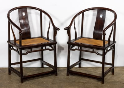 A pair of Chinese hardwood horseshoe chairs with rattan seats