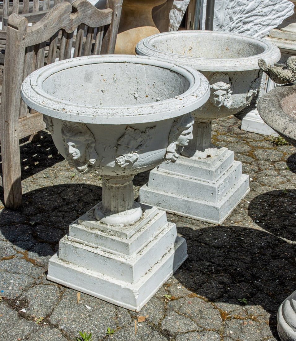 A pair of American Victorian Renaissance Revival cast iron garden urns: A pair of American Victorian Renaissance Revival cast iron garden urns, 19th century, each body with Jenny Lind head reserves and grape and vine detail, overall 31"h x 24"w