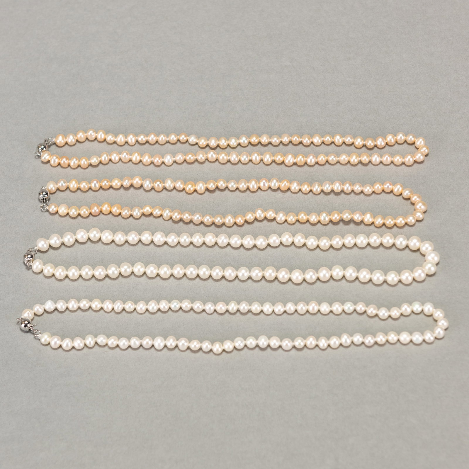 Four Strands of White, and Peach Pearl Necklaces: (lot of 4) Four strands of white, and peach pearl necklaces. Approx. length:16.93"l (43 cm); 49.9 gross dwt.