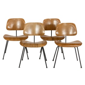 A set of four Eames for Herman Miller walnut faced molded bentwood DCM chairs