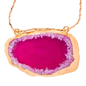 A stone and metal pendant with 18k gold chain