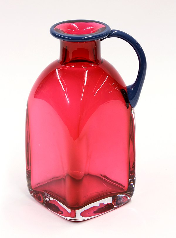 Orrefors cased art glass vase: Orrefors cased art glass vase, the jug form executed in cranberry to clear accented by a blue rim and handle, 8.75"h