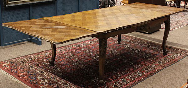 French Provincial style draw leaf dining table: French Provincial style draw leaf dining table, executed in oak, the serpentine parquet top with two leaves above the shaped and incised apron rising on cabriole legs terminating on upswept feet, 28.5