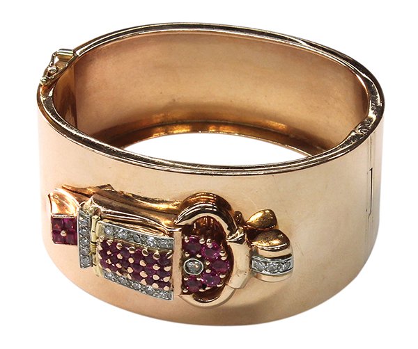 A Retro Era rose gold, diamond and ruby covered watch b: A Retro Era rose gold, diamond and ruby covered watch bangle The hinged watch cover is decorated with diamonds, estimated total weight 0.32 carats; rubies estimated total weight 1.92 carats; seventeen